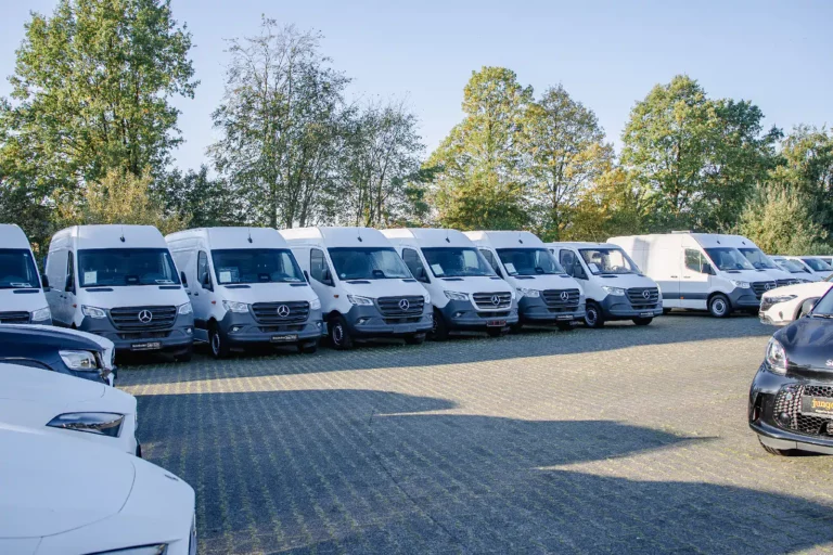 Reihe weißer Mercedes-Benz Sprinter auf dem Außengelände des Autohauses